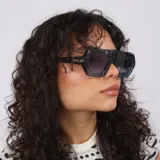 Lentes de sol con armazón de acetato negro de diseño geométrico y estilo envolvente, con cristales oscuros con protección UV400.