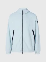 Campera con capucha Calvin Klein, confeccionada en nailon 100% reciclado color celeste. Tiene cierre de cremallera frontal, cuello alto, bolsillos delanteros con cremallera, puños y dobladillo elásticos, tirador de cremallera con la marca e insignia con el logo de Calvin Klein en la manga.