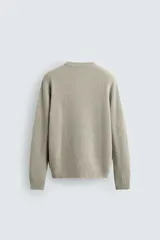 Jersey de punto con corte regular fit, cuello redondo y manga larga. Presenta un diseño de textura acanalada con acabados en rib en puños y bajo.
