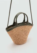 Bolso de mano tipo cesta con cuerpo de fibras naturales trenzadas y detalles en cuero sintético color verde oliva. Cuenta con dos asas cortas, una correa bandolera ajustable y cierre de botón magnético.