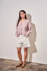 Cardigan de punto texturado en color rosa viejo, con escote en V, cierre frontal de botones y mangas largas con puños acanalados.