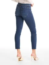 Jean skinny de tiro medio, color azul clásico, con cierre frontal y botón metálico. Cuenta con bolsillos laterales y traseros, y pasadores para cinturón en la cintura.