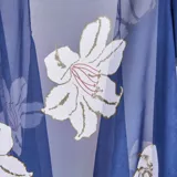 Kimono largo de gasa sintética liviana color azul con estampado de flores blancas. Tiene calce suelto y ruedo irregular con puntas.