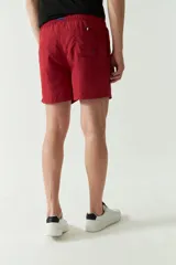 Short de baño liso con cintura elástica y cordón ajustable. Cuenta con dos bolsillos laterales, un bolsillo trasero y logo bordado. Confeccionado en tela ligera de secado rápido.