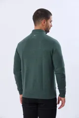 Buzo tejido de punto color verde oscuro, con cuello alto y cierre frontal parcial. Presenta un detalle en cuero en el tirador del cierre y un pequeño logo bordado en el pecho.