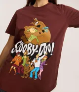 Remera de algodón color marrón oscuro con estampa frontal de los personajes de Scooby-Doo (Scooby, Shaggy, Fred, Daphne y Velma) y el logo de la serie.