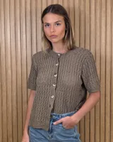 Cardigan de punto calado color tostado, con mangas cortas, cuello redondo y cierre frontal de botones.