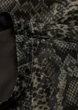 Vestido midi de organza con estampado de serpiente, diseño recto sin mangas y cuello perkins. Cuenta con cierre de cremallera en la parte posterior y abertura en la espalda.