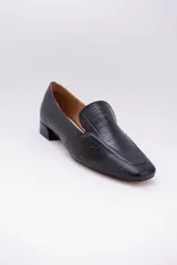 Mocasines bajos de cuero negro con textura croco y suela plana.