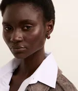 Set de aros dorados con diferentes diseños: aros pequeños con textura de piel de serpiente en marrón y dorado, aros cuadrados y aros pequeños lisos.