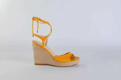 Sandalias de plataforma con taco corrido revestido en yute, confeccionadas en cuero color lila. Presentan diseño de puntera abierta y tiras largas para atar alrededor del tobillo.