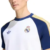 Remera deportiva de manga corta Adidas Originals del Real Madrid, de color blanco con mangas azules y detalles en amarillo. Incorpora el logo del trébol y el escudo del club bordados en el pecho.