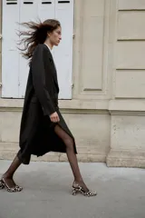 Zapato destalonado de piel con pelo, con estampado animal print. Presenta tacón alto ancho, tira trasera ajustable con hebilla metálica y acabado en punta cuadrada.