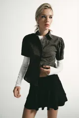 Falda corta de tiro bajo con diseño de volantes en el ruedo y detalle fruncido en la cintura. Confeccionada en tejido con efecto ante, cuenta con cierre lateral mediante cremallera oculta.
