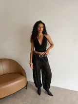 Cinturón de cuero sintético negro con diseño de tachas metálicas plateadas y hebilla grande de metal.