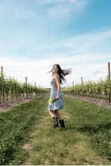 Vestido corto celeste con breteles finos, corte a la cintura, falda con volados y detalle de encaje en ruedo y cintura.