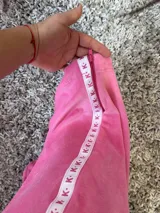 Pantalón de plush rosa chicle con elástico en la cintura y cierres en los tobillos.