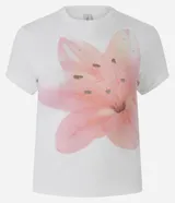 Remera baby tee de algodón color blanco, con cuello redondo, manga corta y un gran estampado frontal de una flor de lirio en tonos rosados con aplicaciones de pedrería.