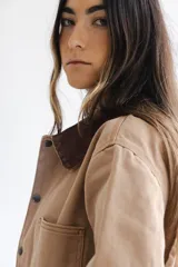 Campera estilo cargo color tostado con cuello de pana marrón, múltiples bolsillos delanteros y cierre frontal con botones a presión.