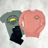 Buzo color salmón de algodón con cuello redondo, puños y cintura acanalados. Estampado en el frente con un sol y el texto "Only Good Vibes Surf Duxon Co. 3-77 Vissla St. California, USA 92672".