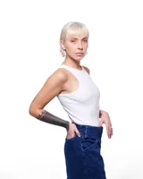 Pantalón de denim azul con corte sastrero de pierna ancha, tiro alto, cierre frontal invisible y pretina cruzada. Aplique de caballo/dragón en bronce hecho a mano y bordado negro del logo Temblad en la parte trasera.