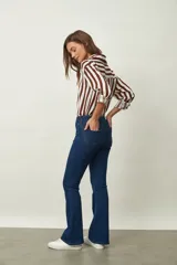 Jean de corte oxford en color negro, con tiro medio y ajuste en la cintura y caderas, ensanchándose desde la rodilla hacia el ruedo.