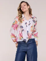Camisa de gasa blanca con estampado floral multicolor, cuello con solapa, mangas largas y cierre frontal con botones. Cuenta con terminación delantera anudada y espalda más larga.