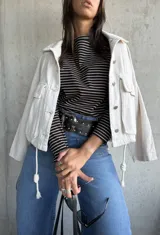 Remera de manga larga con cuello redondo, confeccionada en tejido de algodón con diseño de rayas horizontales finas en color negro y beige.