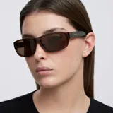 Lentes de sol con diseño rectangular y envolvente de estilo deportivo. Montura de material bio-based color mostaza con lentes polarizadas color marrón.