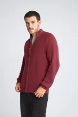 Campera tejida de algodón con cierre frontal completo, cuello alto y mangas largas con puños acanalados. Presenta un diseño de punto acanalado vertical y un pequeño logo bordado en el ruedo.