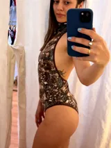 Body reversible de cuello alto y espalda descubierta, confeccionado con tejido de lycra elastizada de calce entallado, con un estampado abstracto en tonos oscuros y marrones.