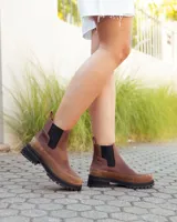 Botinetas estilo Chelsea de cuero marrón, con paneles laterales elásticos en color negro y suela track dentada de goma negra.