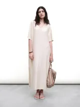 Vestido midi negro con cuello en V, mangas cortas y aberturas laterales. Confeccionado en tejido fluido con un toque de lurex.