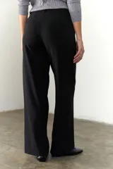 Pantalón marrón de corte recto y pierna ancha, con cintura alta, bolsillos laterales y cierre.