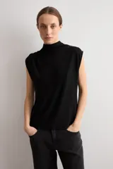 Blusa de lurex negra sin mangas, con cuello alto drapeado y detalle de pliegues frontales.