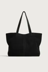Bolso tipo shopper color negro, fabricado en piel con acabado serraje, cuenta con compartimento principal con cierre imantado y dos asas de hombro.