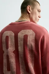 Sudadera de corte boxy fit con cuello redondo y manga larga. Presenta un diseño con efecto lavado y estampado frontal con la palabra Milano en tipografía universitaria a contraste.