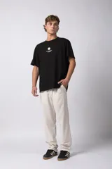 Remera de corte oversize color verde oliva, confeccionada en algodón premium. Presenta un diseño minimalista con un pequeño estampado frontal de un sol y el texto VCP Concept Studio, y una gráfica protagonista en la espalda.