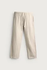 Pantalón de corte relajado confeccionado en una mezcla de algodón y lino. Presenta cintura elástica con cordón ajustable, bolsillos laterales y bolsillos traseros de vivo.