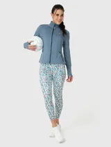 Campera deportiva de entrenamiento con cierre frontal completo, cuello alto y mangas largas con orificio para pulgar. Confeccionada en tejido técnico suave de color azul denim melange, cuenta con bolsillos laterales con cierre y costuras reforzadas.
