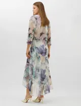 Conjunto compuesto por un vestido midi de gasa con estampado floral en tonos violeta, azul y crema, con escote en V, tirantes anchos y ruedo asimétrico con volados. Incluye una chaqueta corta tipo torera de mangas 3/4 confeccionada en la misma tela. Posee forro interno a tono.