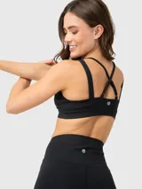 Conjunto deportivo compuesto por un top de escote en V con breteles cruzados en la espalda y un pantalón tipo calza de corte acampanado con cintura alta plegable.