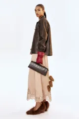 Cartera rectangular con textura efecto piel de cocodrilo, solapa con cierre magnético oculto, asa superior fija y correa larga ajustable y extraíble.
