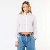 Camisa blanca de manga larga con diseño cropped, cuello camisero, cierre frontal con botones y detalles de bordados all over con perforaciones.
