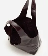 Cartera shopper grande Satinato de poliuretano color negro, con acabado texturizado brillante, diseño amplio y asa de hombro ancha.