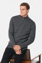 Buzo tejido de lana con cuello alto y medio cierre metálico frontal. Presenta puños y ruedo acanalados, con logo bordado en el pecho.