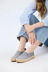 Chatita de lona color gris, con diseño slip-on sin cordones y suela revestida con textura de yute.