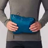 Campera azul con cierre frontal, cuello alto y bolsillo negro en el pecho con logo de la marca.