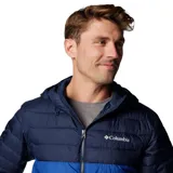 Campera técnica con capucha, diseño acolchado en dos tonos de azul, cierre frontal completo y bolsillos laterales con cremallera. Cuenta con tecnología de aislamiento térmico y tejido resistente al agua.