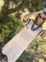 Remerón tejido de punto color azul marino con calados, cuello estilo camisa en verde oscuro con rayas blancas y verdes, y logo bordado en blanco en el pecho.